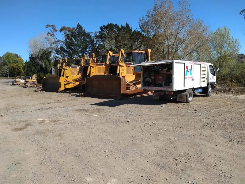 A line of bulldozers next to the Mobile Auto Air truck